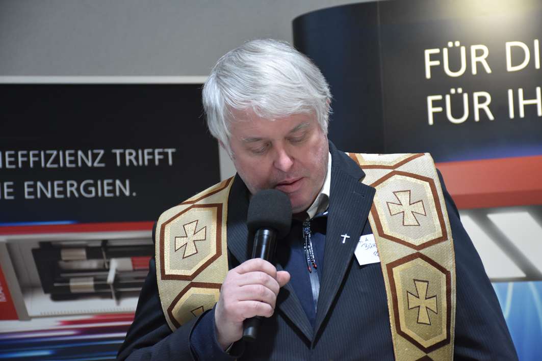 Mand taler i mikrofon ved arrangement