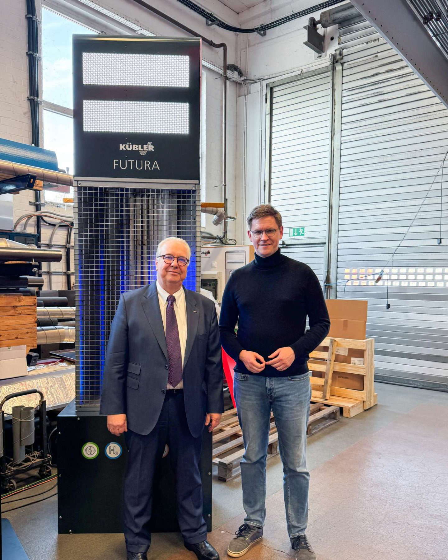 Zwei Männer neben futuristischem Display in Werkstatt