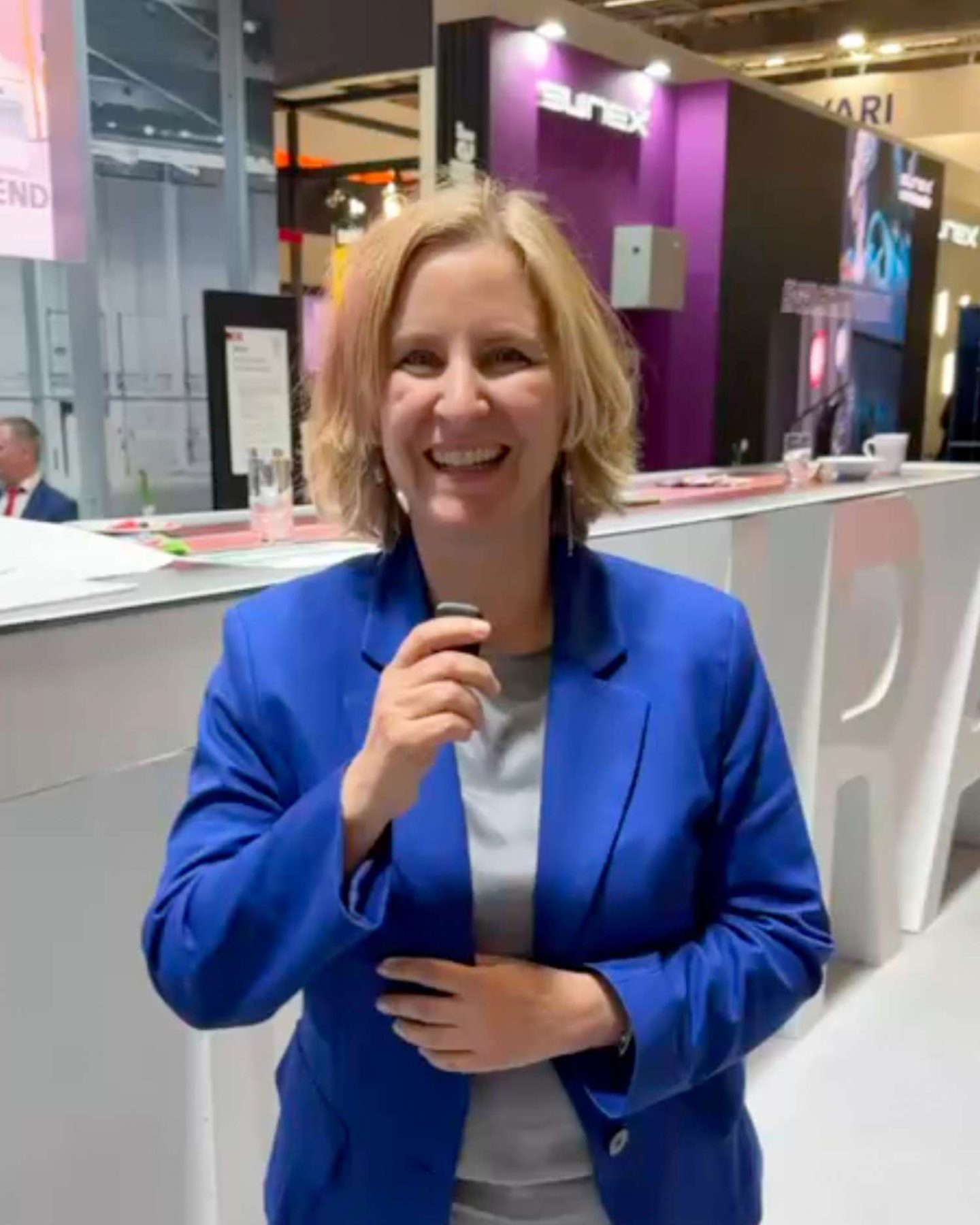 Frau in blauem Anzug spricht in Mikrofon