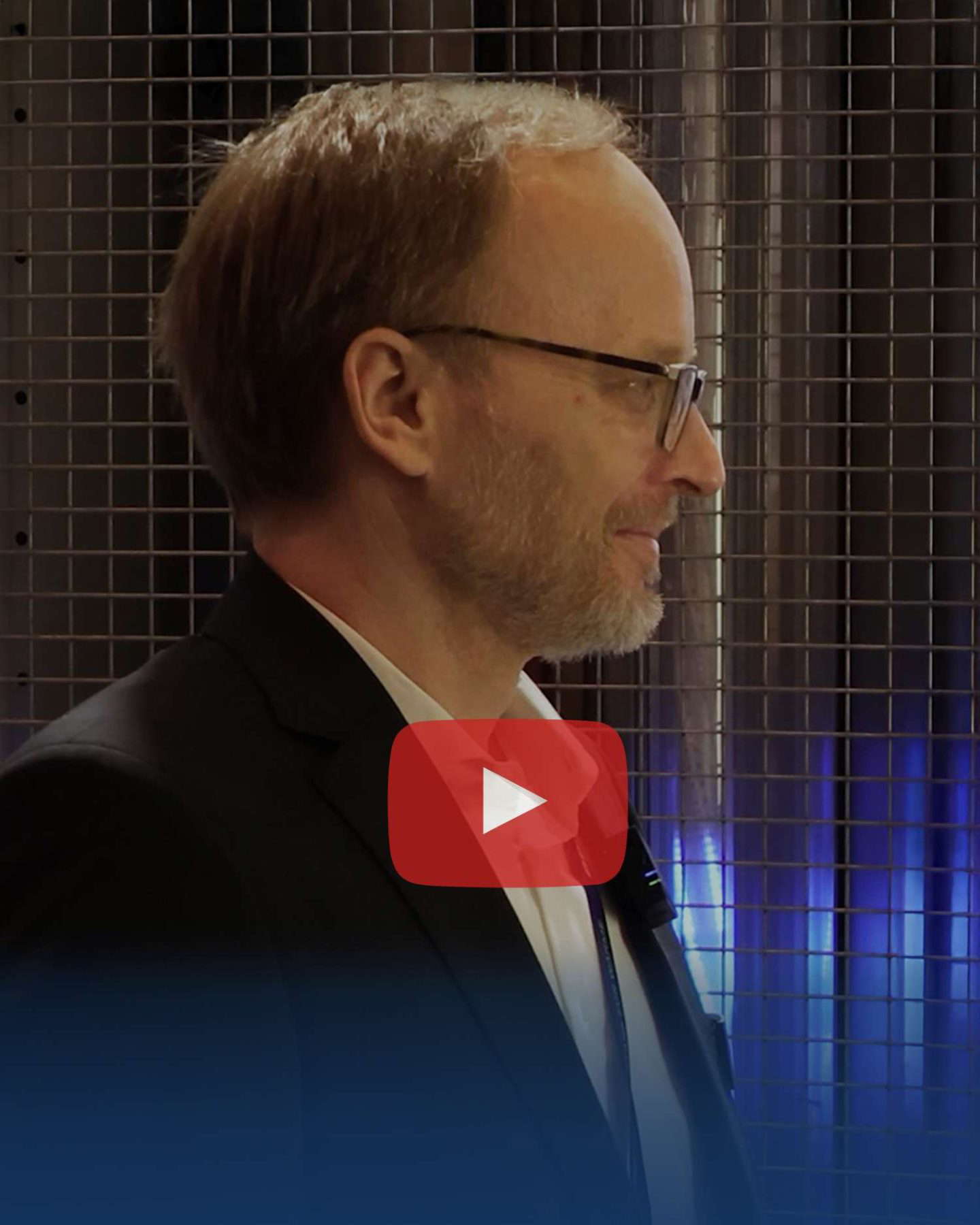 Mann mit Brille im Anzug vor YouTube-Logo