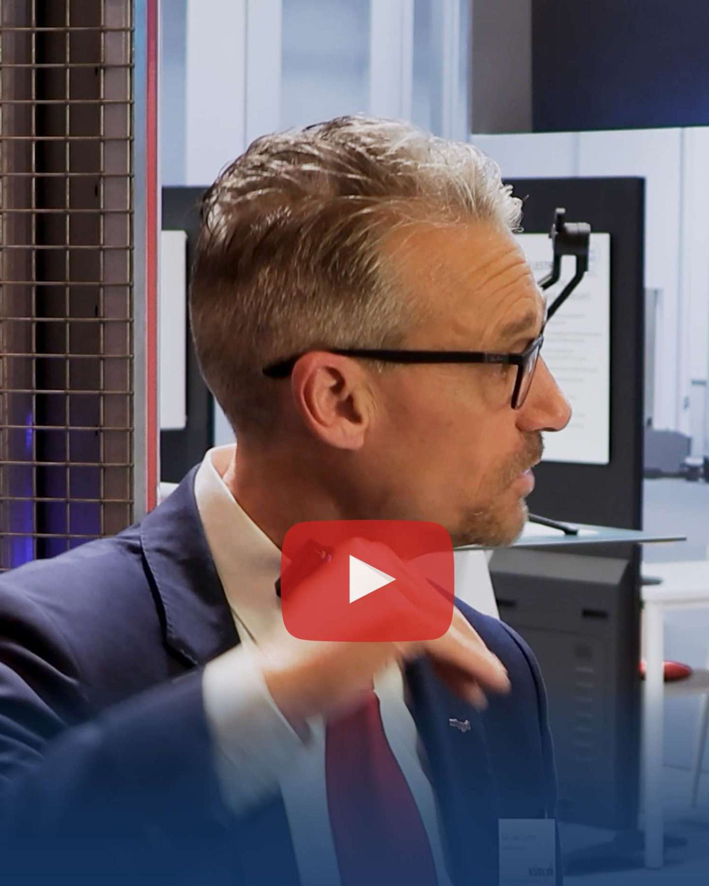 Man in suit speaks in front of camera