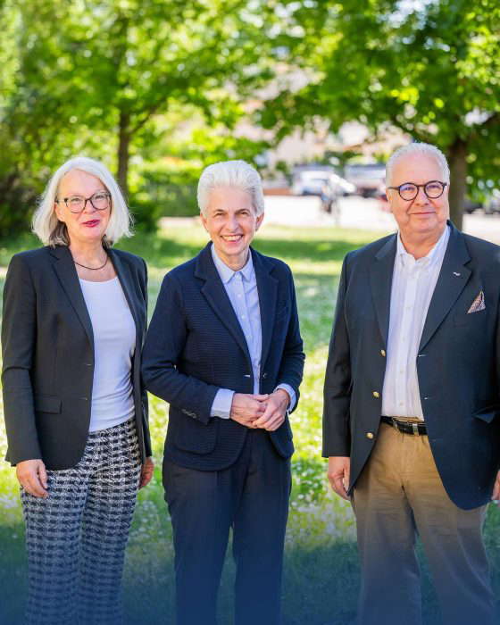 Kolme liikemiestä seisoo ulkona