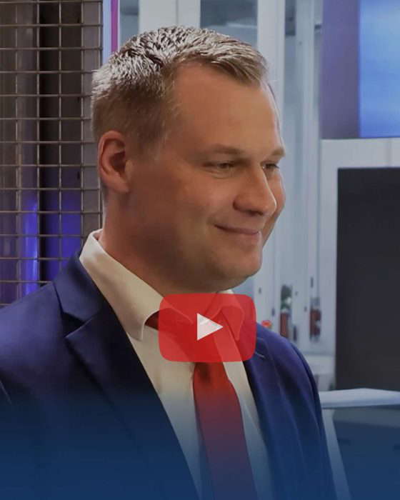 Pukumies hymyilee YouTube-kuvakkeen edessä