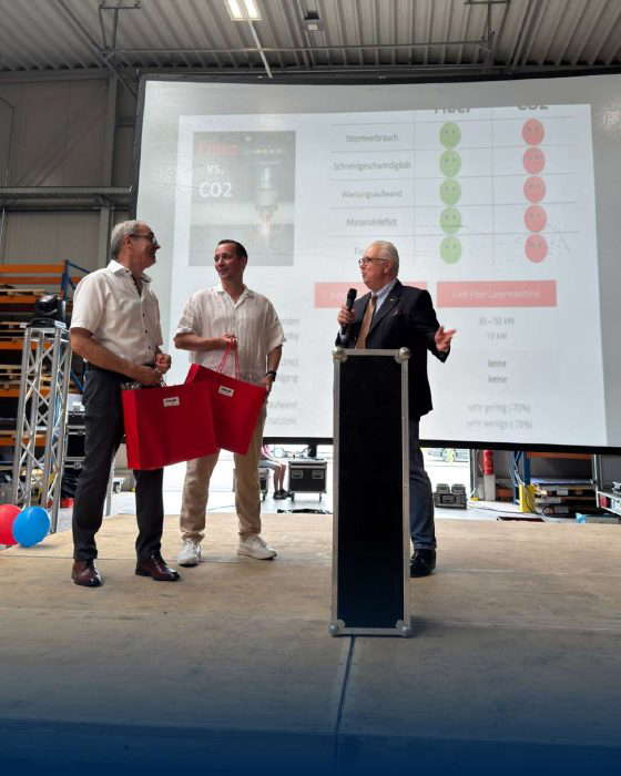 Miehet esittelevät tiedotusgrafiikkaa tapahtuman aikana