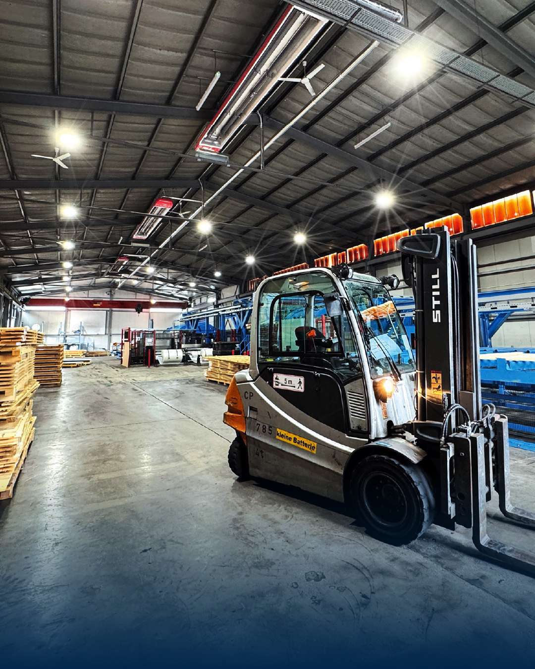 Gaffeltruck i oplyst lagerhal