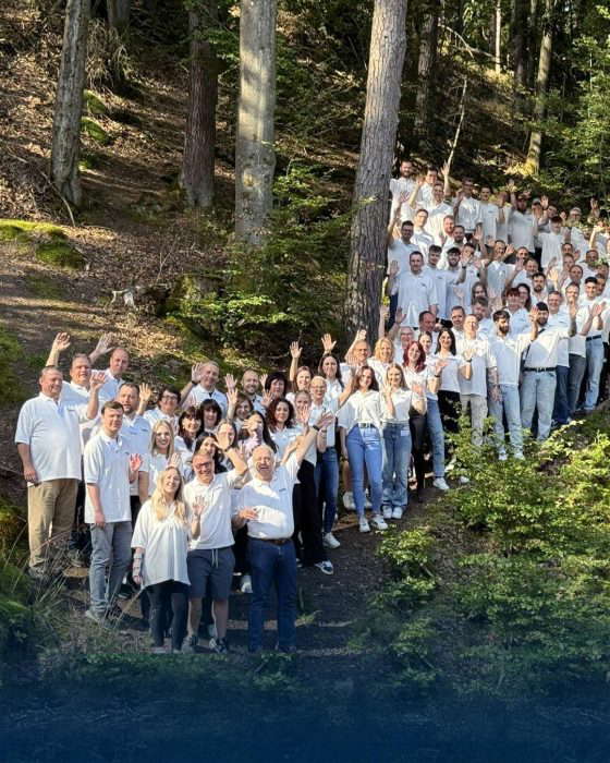 Ryhmäkuva ihmisistä metsässä vilkuttamassa