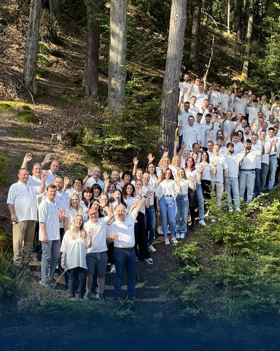 Ryhmäkuva ihmisistä metsässä vilkuttamassa