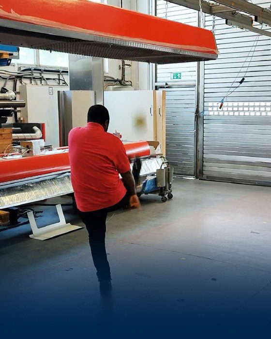 Mies juoksee teollisuusverstaassa