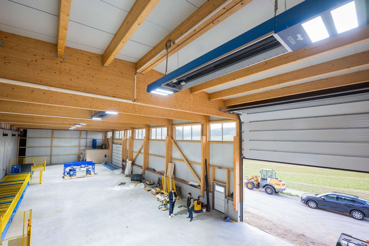 Moderne Halle mit Arbeitern und Baumaschinen