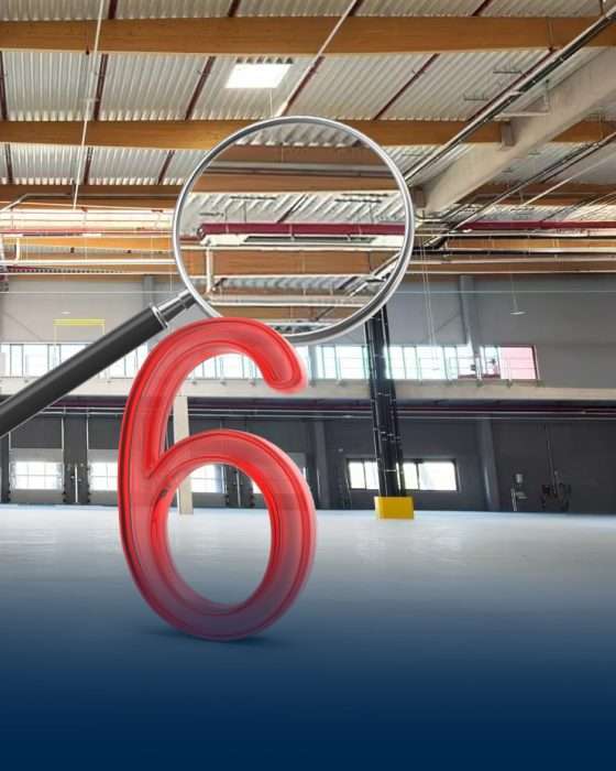 Rote Zahl sechs mit Lupe in Industriehalle